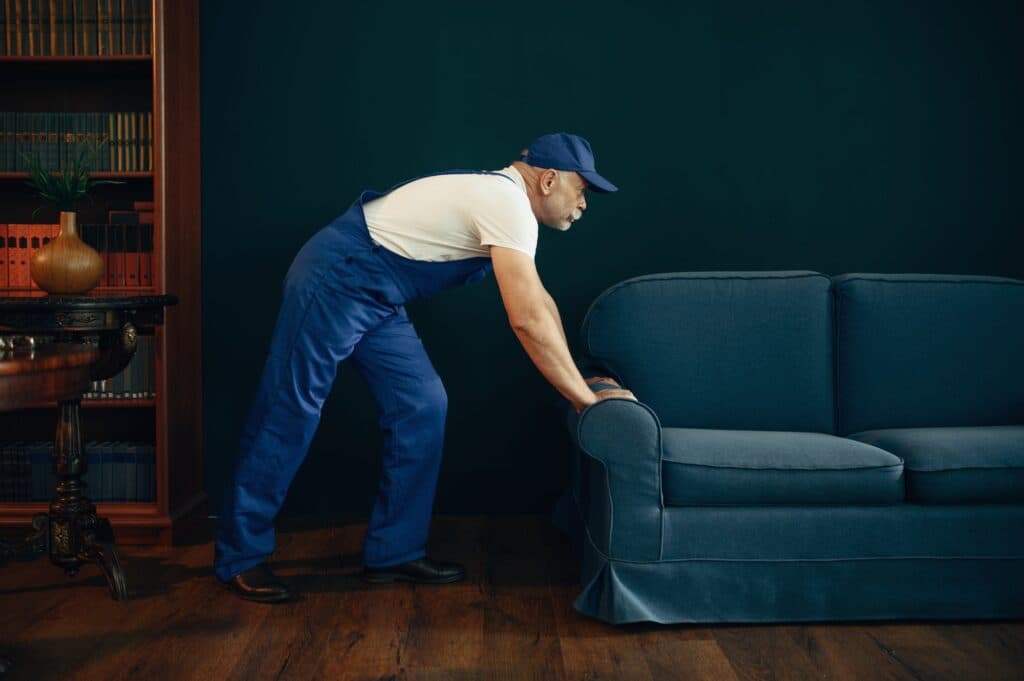 Mover in uniform moving a sofa